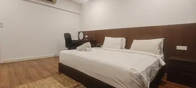 a bedroom with a large bed with a wooden headboard at Signature Apartment at Mercu Summer Suites KLCC in Kuala Lumpur