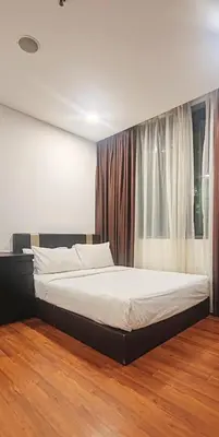 a bedroom with a large bed in front of a window at Signature Apartment at Mercu Summer Suites KLCC in Kuala Lumpur