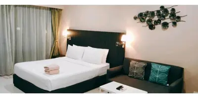 a hotel room with a bed and a chair in it at Signature Apartment at Mercu Summer Suites KLCC in Kuala Lumpur