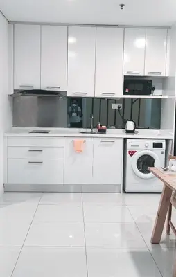 a kitchen with white cabinets and a washing machine at Signature Apartment at Mercu Summer Suites KLCC in Kuala Lumpur