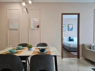 a dining room with a table and chairs and a bedroom at Sky Suites KLCC by Asiapex in Kuala Lumpur