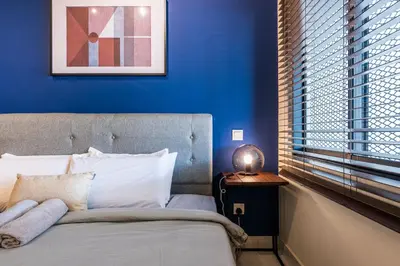 a bedroom with a bed with a blue wall at 3BR Family-Friendly Landed House,PandanPerdana,KL by Verano in Kuala Lumpur