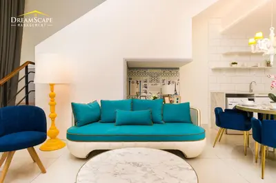 a living room with a blue couch and chairs at Arte Mont Kiara in Kuala Lumpur