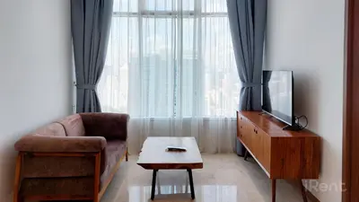 a living room with a couch and a tv and a table at Sky Suites KLCC by iRent365 in Kuala Lumpur
