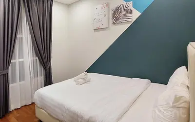 a bedroom with a white bed with a green wall at Sky Suites KLCC by iRent365 in Kuala Lumpur