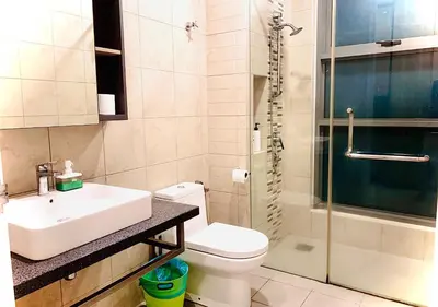 a bathroom with a toilet and a sink and a shower at Robertson PanoramaKL Suites in Kuala Lumpur