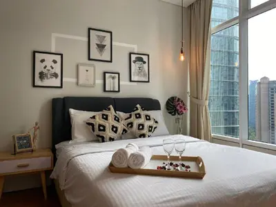 a bed with a tray of towels and a window at Sky Suite KLCC Studio Suite in Kuala Lumpur