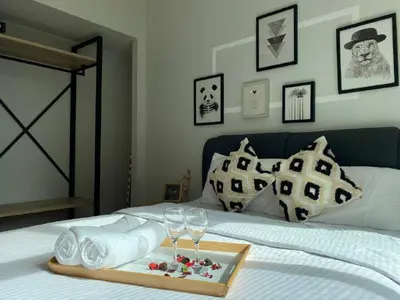 a bed with a tray of towels and wine glasses at Sky Suite KLCC Studio Suite in Kuala Lumpur