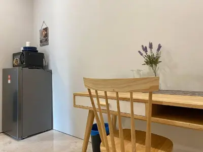 a wooden table and a refrigerator in a room at Sky Suite KLCC Studio Suite in Kuala Lumpur