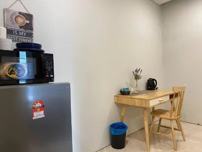 a kitchen with a small table next to a refrigerator at Sky Suite KLCC Studio Suite in Kuala Lumpur