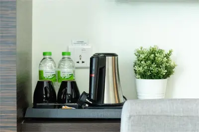 a coffee maker and bottles of water and a plant at Ramada Encore by Wyndham Chinatown Kuala Lumpur in Kuala Lumpur