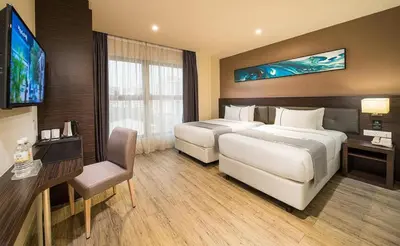 a hotel room with two beds and a flat screen tv at Ramada Encore by Wyndham Chinatown Kuala Lumpur in Kuala Lumpur