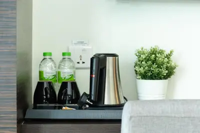 a coffee maker and bottles of water and a plant at Ramada Encore by Wyndham Chinatown Kuala Lumpur in Kuala Lumpur