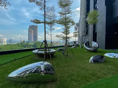 a park with trees and swings on the grass at Arte Mont Kiara by CozyNest in Kuala Lumpur