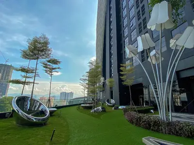 a park with green grass and trees on a building at Arte Mont Kiara by CozyNest in Kuala Lumpur