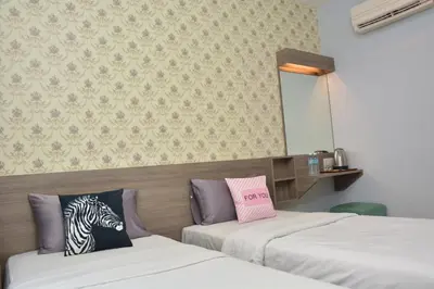 a room with two beds and a mirror at DUTA HOTEL in Kuala Lumpur