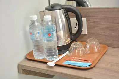 a tray with two bottles of water and glasses on a counter at DUTA HOTEL in Kuala Lumpur