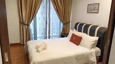 a bed with two pillows on it in front of a window at One Maxim Residence at Taragon in Kuala Lumpur