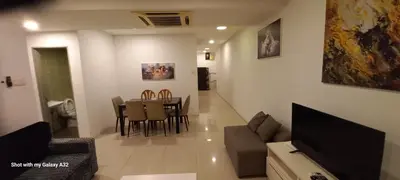 a living room with a couch and a table with chairs at One Maxim Residence at Taragon in Kuala Lumpur