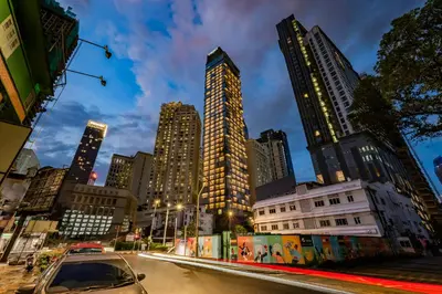 a car driving down a city street with tall buildings at Capri by Fraser, Bukit Bintang in Kuala Lumpur