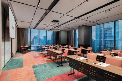 a conference room with tables and chairs and large windows at Capri by Fraser, Bukit Bintang in Kuala Lumpur