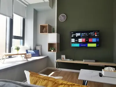 a living room with a tv on a green wall at Ceylonz Suites KL Studio near Bukit Bintang - Living Signature in Kuala Lumpur