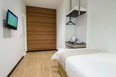 a bedroom with a bed and a sliding door with a television at 12FLY Hotel Kuala Lumpur in Kuala Lumpur