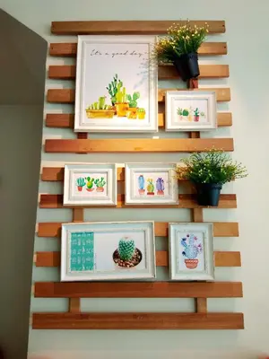 a wall with framed pictures and potted plants at Maple Inn in Kuala Lumpur