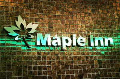 a sign on a brick wall with the word magic inn at Maple Inn in Kuala Lumpur