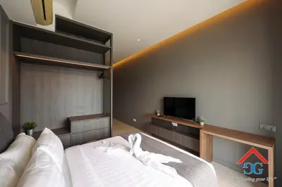 a bedroom with a bed with white sheets and a tv at The Elements by Grabstay in Kuala Lumpur