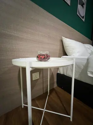 a white table with a bowl on it next to a bed at Mercu Summer Suites KLCC by SS Residence in Kuala Lumpur