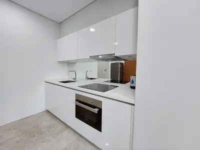 a white kitchen with a sink and a stove at Sky Suites with KLCC Twin Tower View by iRent365 in Kuala Lumpur