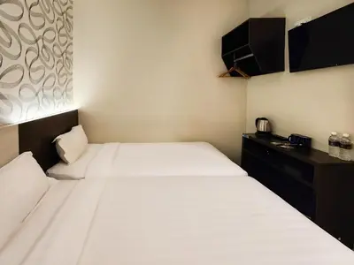 a hotel room with two beds and a desk at Izumi Hotel Bukit Bintang Kuala Lumpur in Kuala Lumpur
