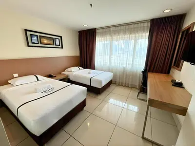 a hotel room with two beds and a television at Seeds Hotel Premier Pudu Kuala Lumpur Previously Hotel Pudu Plaza KL in Kuala Lumpur
