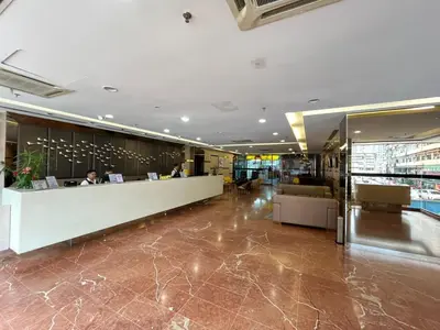 a lobby of a building with people sitting at a counter at Seeds Hotel Premier Pudu Kuala Lumpur Previously Hotel Pudu Plaza KL in Kuala Lumpur