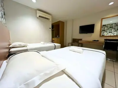 a hospital room with two beds and a tv at Seeds Hotel Premier Pudu Kuala Lumpur Previously Hotel Pudu Plaza KL in Kuala Lumpur