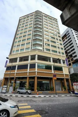 a large building with cars parked in front of it at Metro Hotel Bukit Bintang in Kuala Lumpur