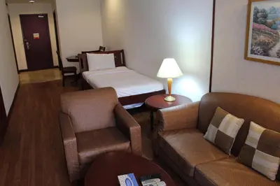 a hotel room with a bed and a couch at Fantazya Suites Times Square in Kuala Lumpur