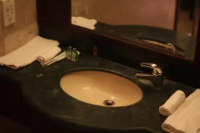 a bathroom counter with a sink and a mirror at Fantazya Suites Times Square in Kuala Lumpur