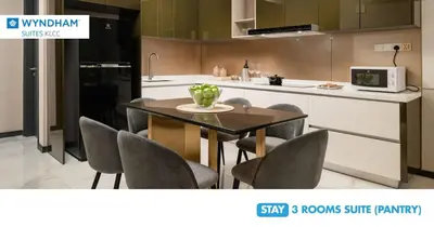 a kitchen with a table with chairs and a microwave at Wyndham Suites KLCC in Kuala Lumpur