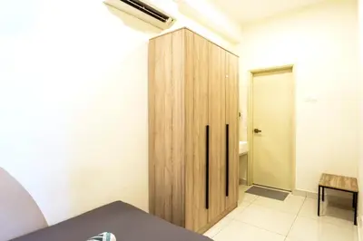 a room with a wooden cabinet in the corner at Arte Mont Kiara by Airhost in Kuala Lumpur