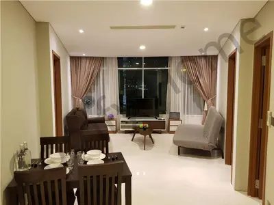 a living room with a table and chairs and a television at KLCC Service suites by Home Sweet Home in Kuala Lumpur