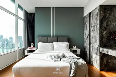 a bedroom with a large white bed with a fireplace at KLCC Homestay Vacation Sky Suites KLCC Birdy Stay in Kuala Lumpur