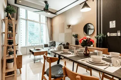 a living room with a table and chairs and a couch at KLCC Homestay Vacation Sky Suites KLCC Birdy Stay in Kuala Lumpur