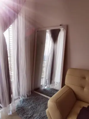 a living room with white curtains and a couch at Aishiteru Homestay in Kuala Lumpur