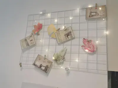 a white tiled wall with pictures and lights at Aishiteru Homestay in Kuala Lumpur