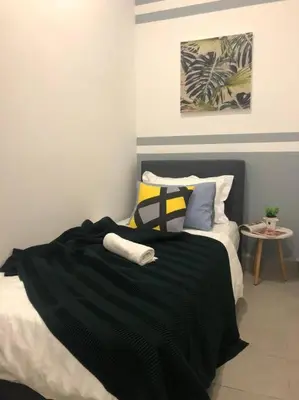 a bedroom with a black blanket on a bed at KL Gateway Premium Residence I HomeBrickz in Kuala Lumpur