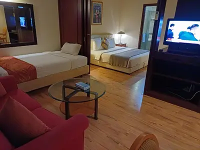 a hotel room with two beds and a couch and a tv at Times Square Grand Service Suite in Kuala Lumpur
