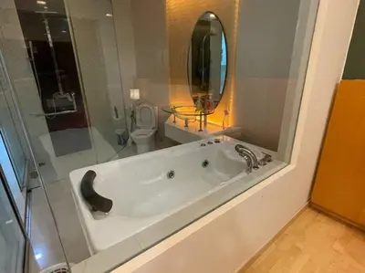 a bathroom with a tub and a toilet and a mirror at Stylish Romantic Couples Getaway at KL City 1419 in Kuala Lumpur