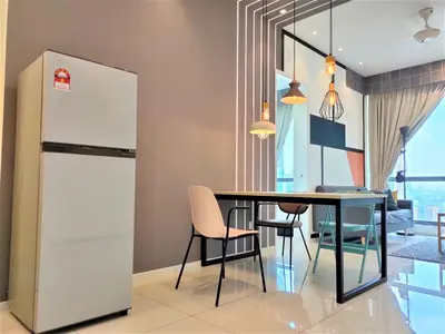 a kitchen and dining room with a table and a refrigerator at Infini Suites@ The Robertson Bukit Bintang in Kuala Lumpur